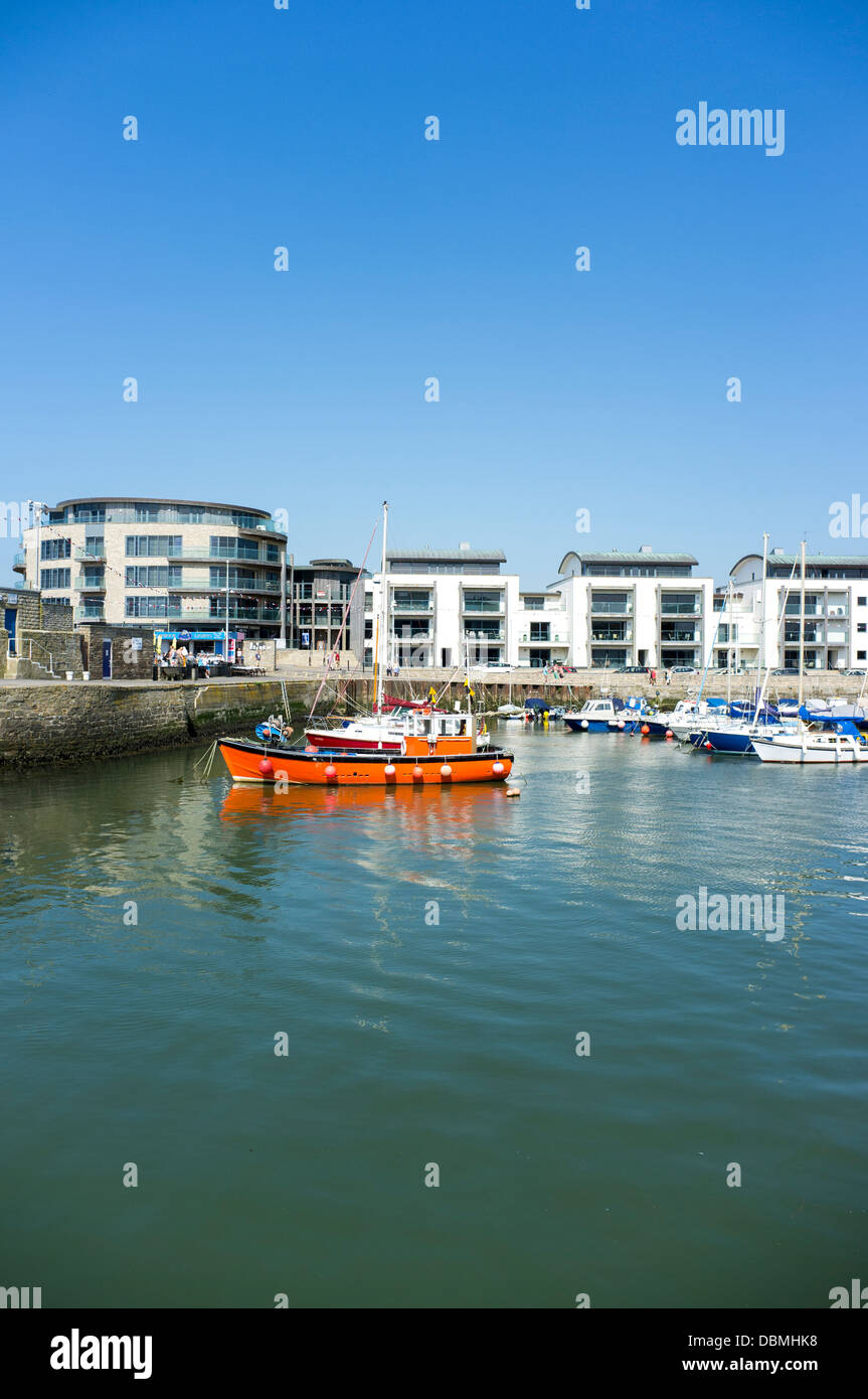 Small orange fishing boat and pleasure craft in West Bay Harbour Dorset ...