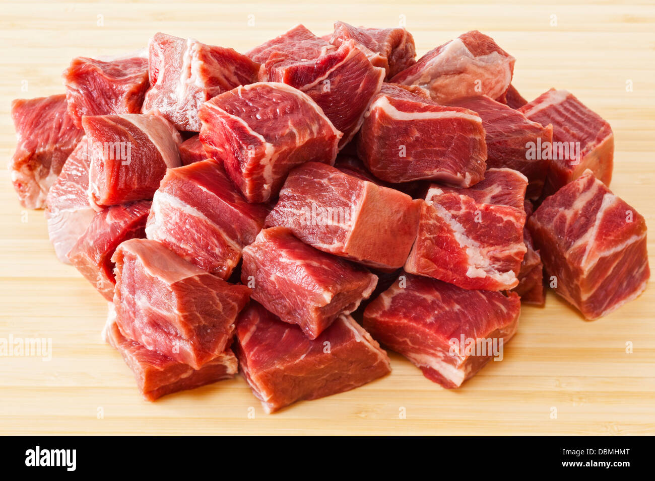 Beef Stew Meat Raw - diced raw blade or chuck steak, on white background. Stock Photo
