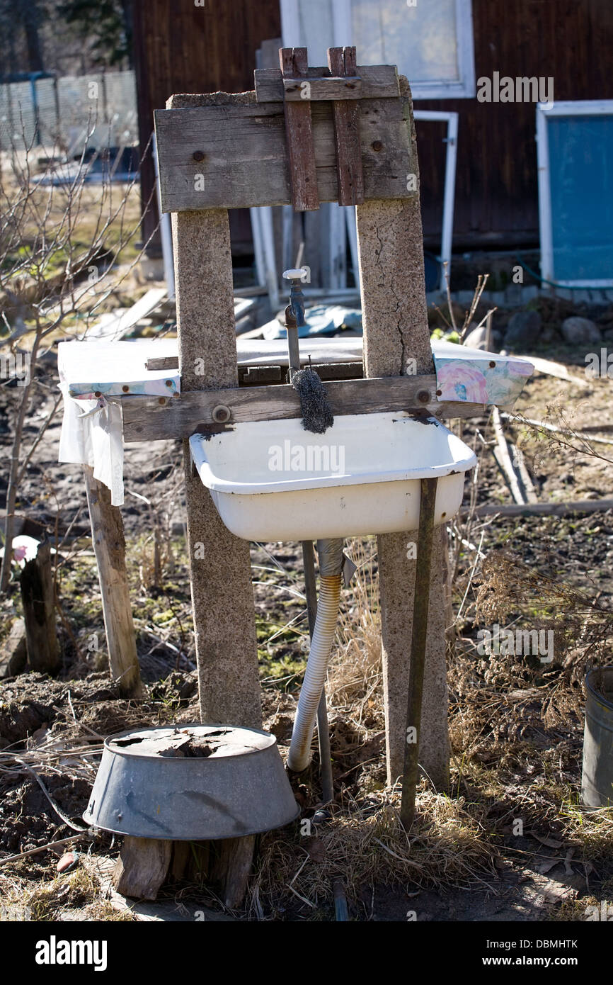 old rural outdoor washstand with white metal sink Stock Photo