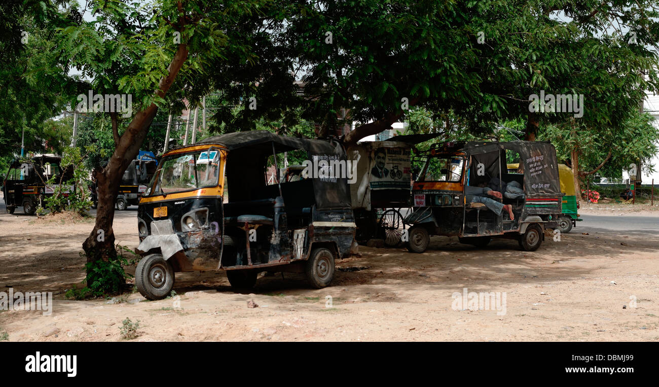 Tut Tut taxi drivers relaxing and sleeping in the shade of a tree, Gurgaon, Haryana. India Stock Photo