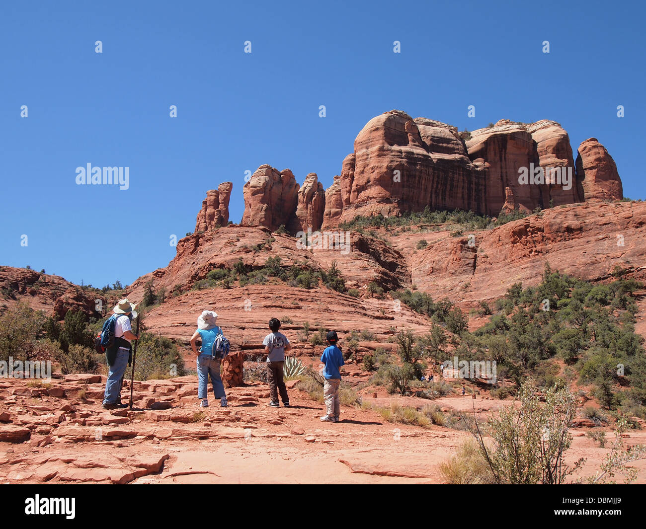 Hikers stop to have a look up at Cathedral Rock, a magnetic (feminine) energy vortex, in Sedona, Arizona, USA Stock Photo