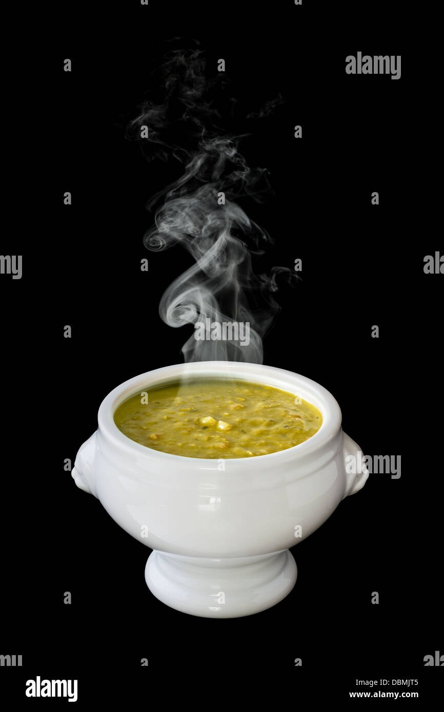 Pea Soup - a bowl of steaming hot pea soup, in a lion head bowl, on a black background, front to back focus and... Stock Photo