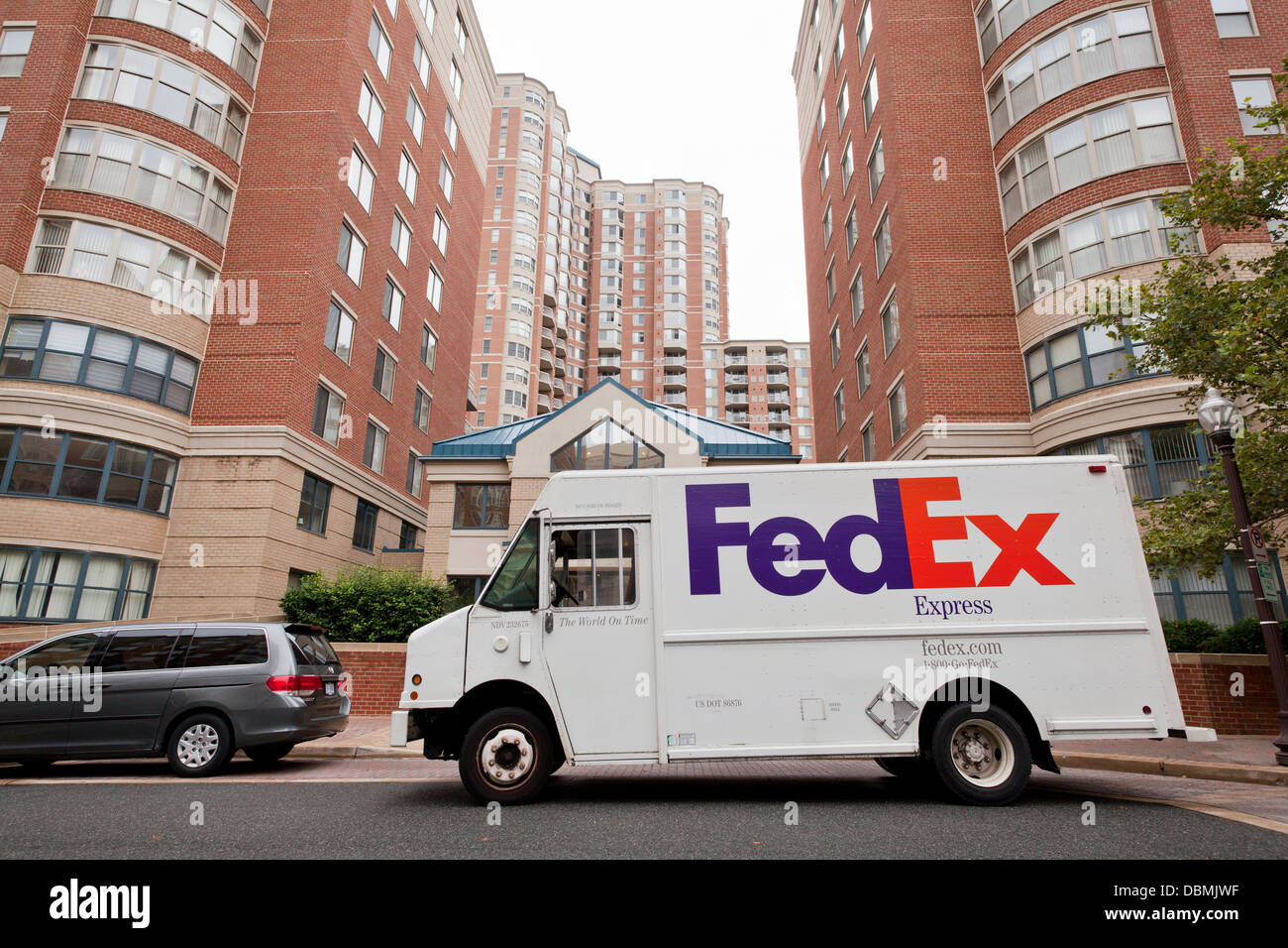 FedEx delivery truck parked in front of apartment building Stock Photo