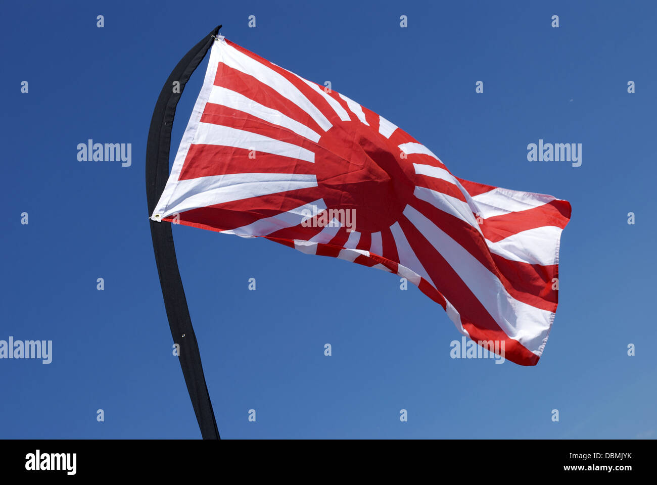 Rising sun flag wavering and fluttering movement on blue sky on windy day Stock Photo
