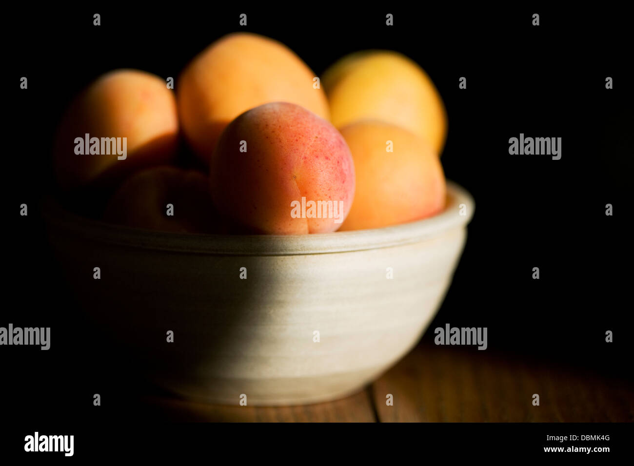 Prunus armeniaca. Sunlight on a bowl of apricots. Stock Photo