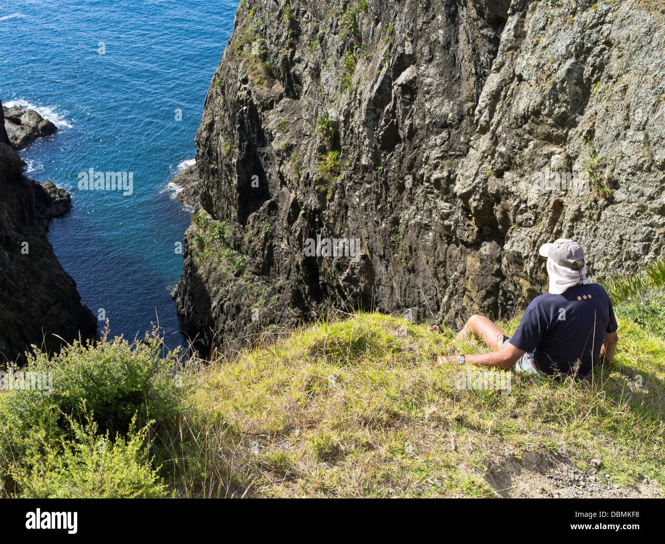 dh Urupukapuka Island BAY OF ISLANDS NEW ZEALAND Man viewing islands craggy cliff shoreline Stock Photo