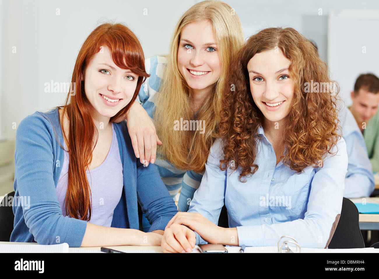 Three young happy attractive women in university class Stock Photo