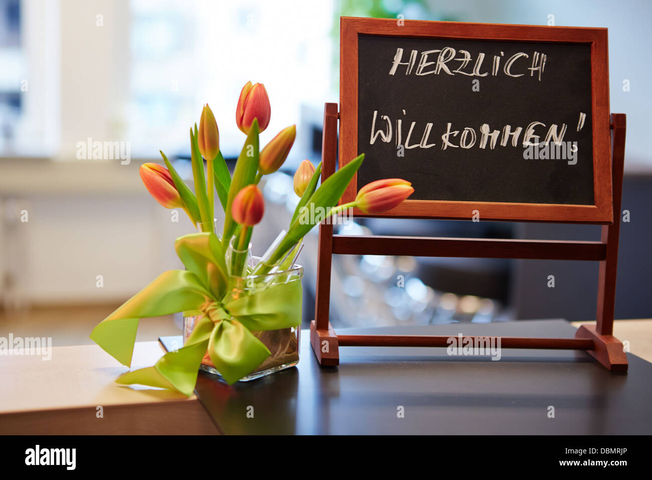 Blackboard with german 'Herzlich Willkommen' welcome slogan Stock Photo