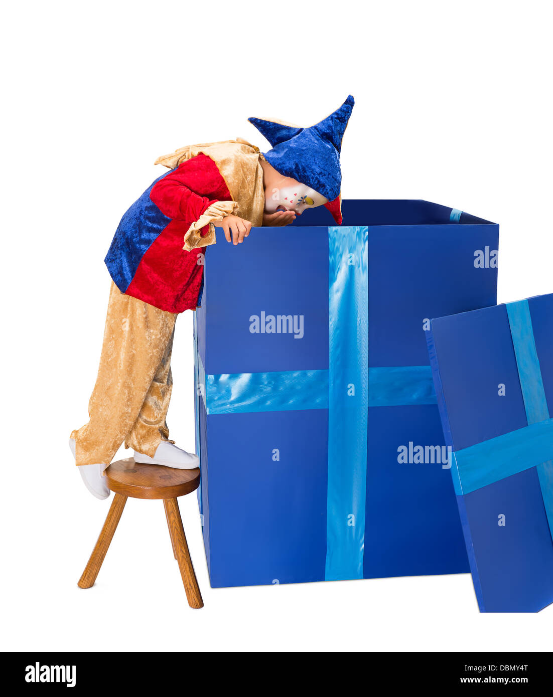 Funny jester clown girl looking deep into a big blue surprise box Stock Photo