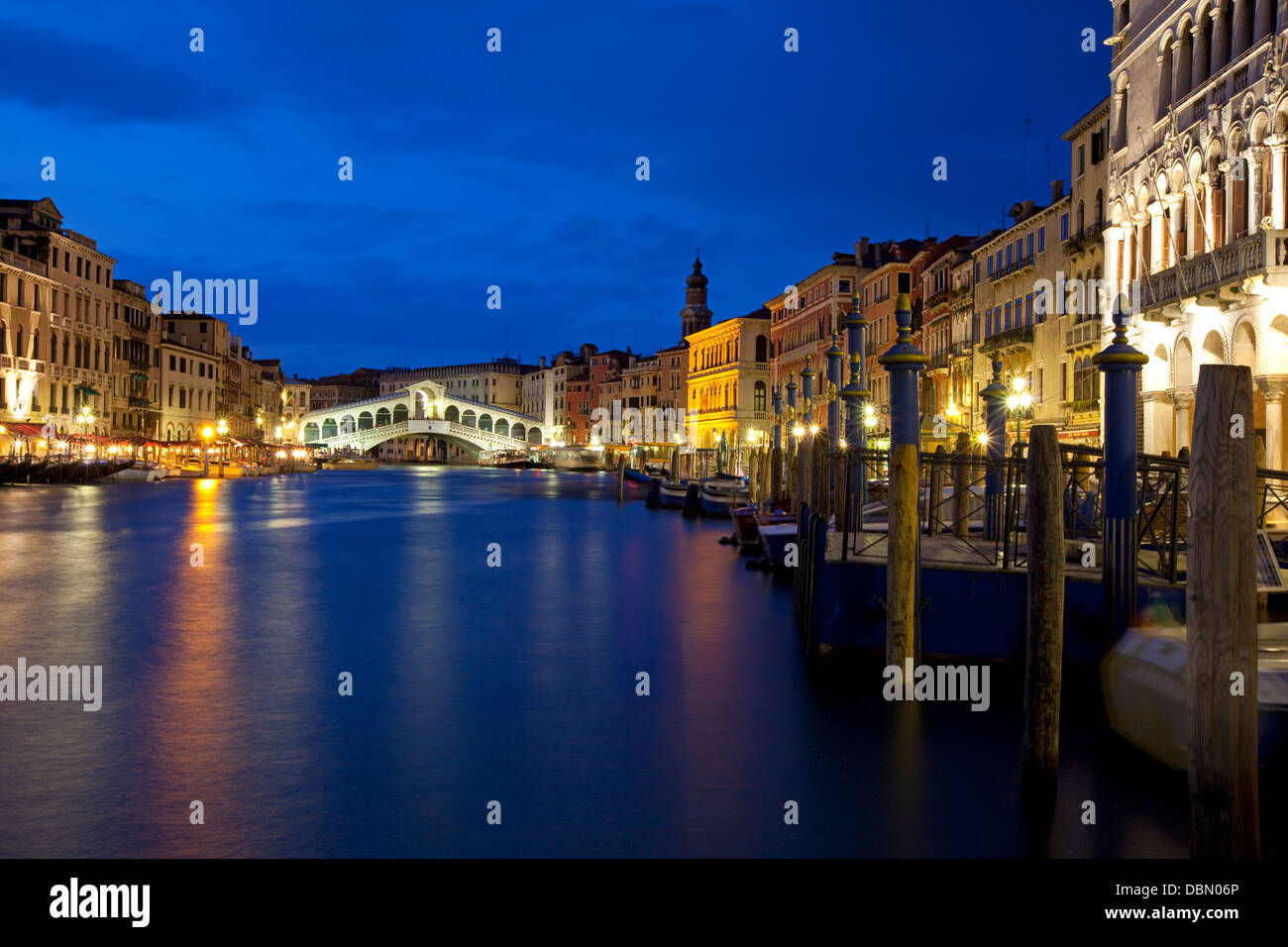 Tranquil, evening scene in the Rialto district in Venice. View of the famous Rialto bridge spanning the Grande Canal with lights Stock Photo