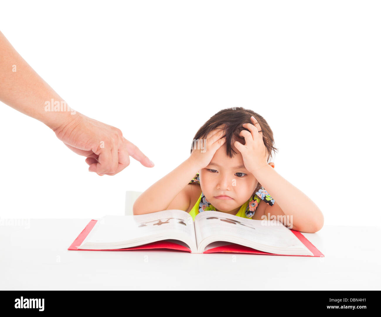 finger pointing to Angry and tired little girl studying Stock Photo