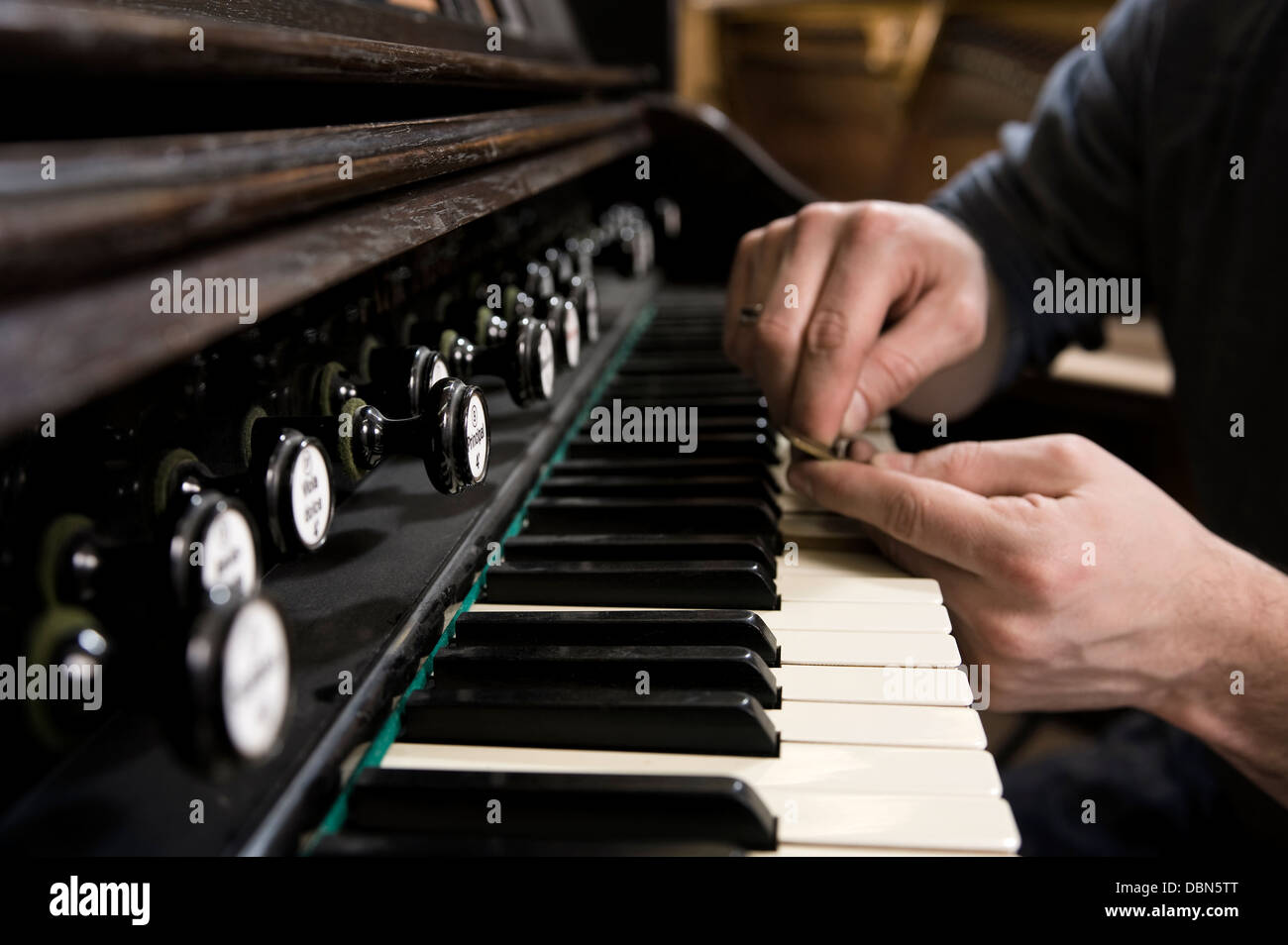 Instrument maker adjusting piano keys, Regensburg, Bavaria, Germany Stock Photo
