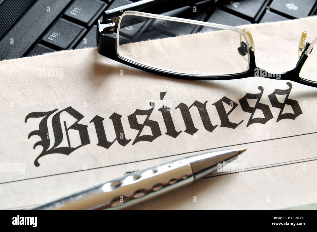 Business, glasses and ball pen on newspaper headline Stock Photo