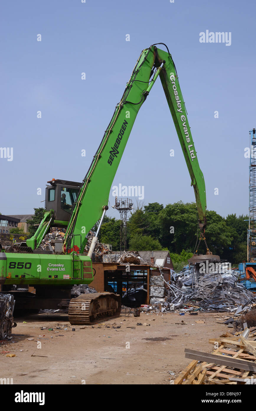 magnetic grab on crane lifting metal at scrapyard uk Stock Photo