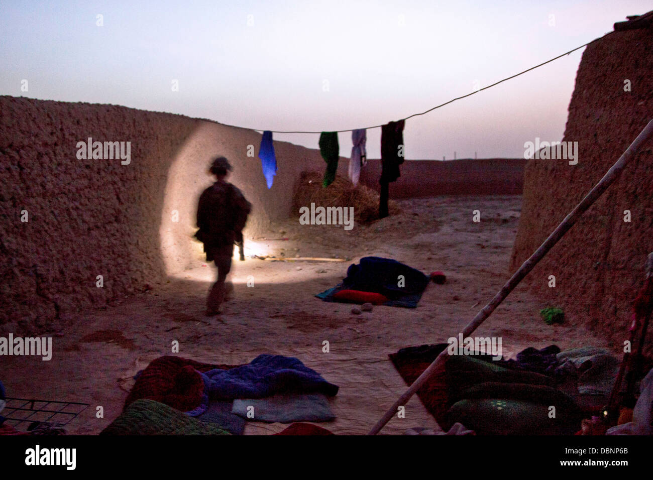 A US Marine checks an Afghan village compound during Operation Grizzly July 18, 2013 in Helmand province, Afghanistan. Stock Photo