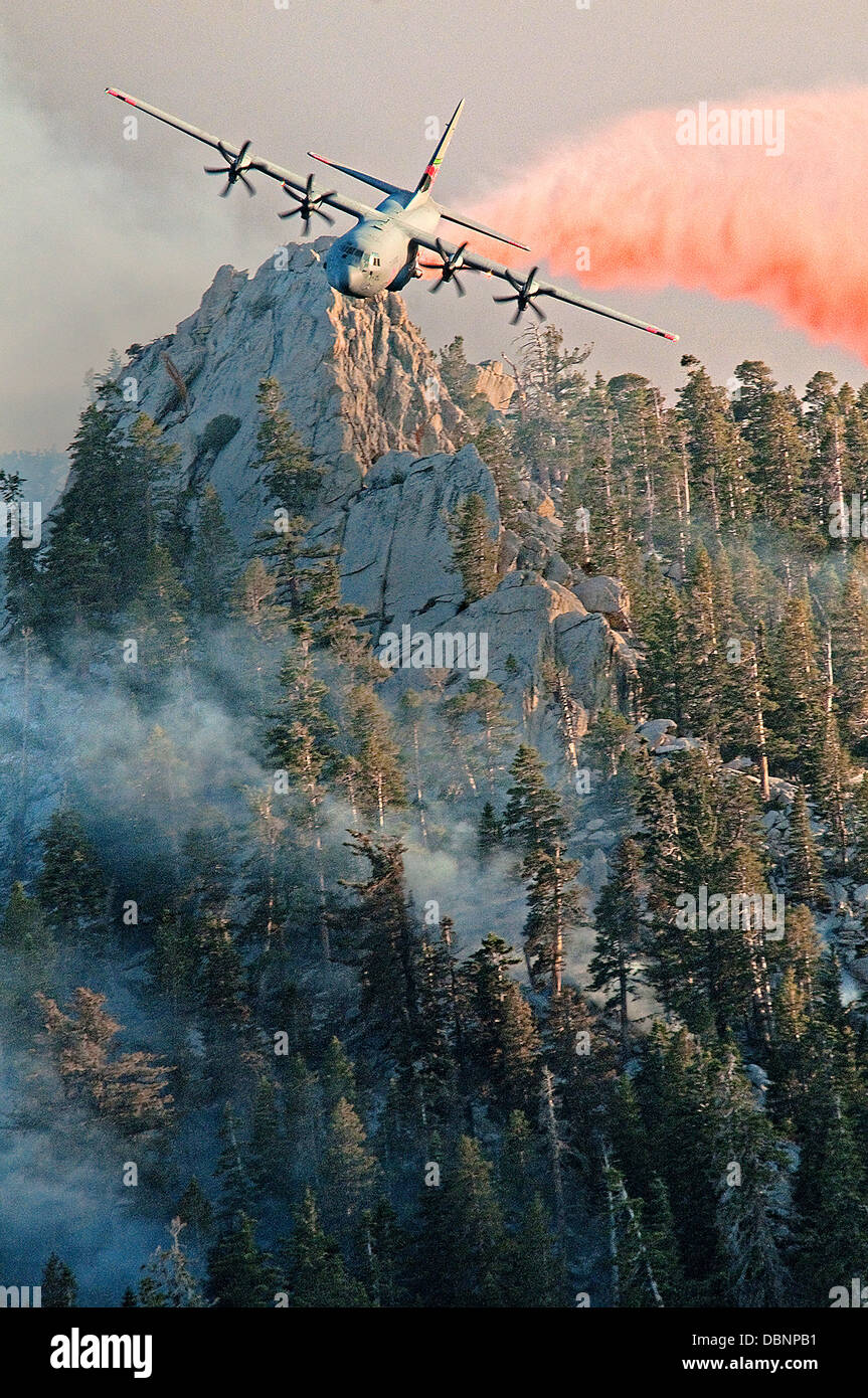 A California Air National Guard C-130 Hercules aircraft releases fire retardant over wildfires in the mountains July 19, 2013 above Palm Springs, CA. Stock Photo