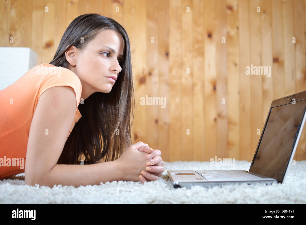 A young woman with a laptop laying in her room Stock Photo