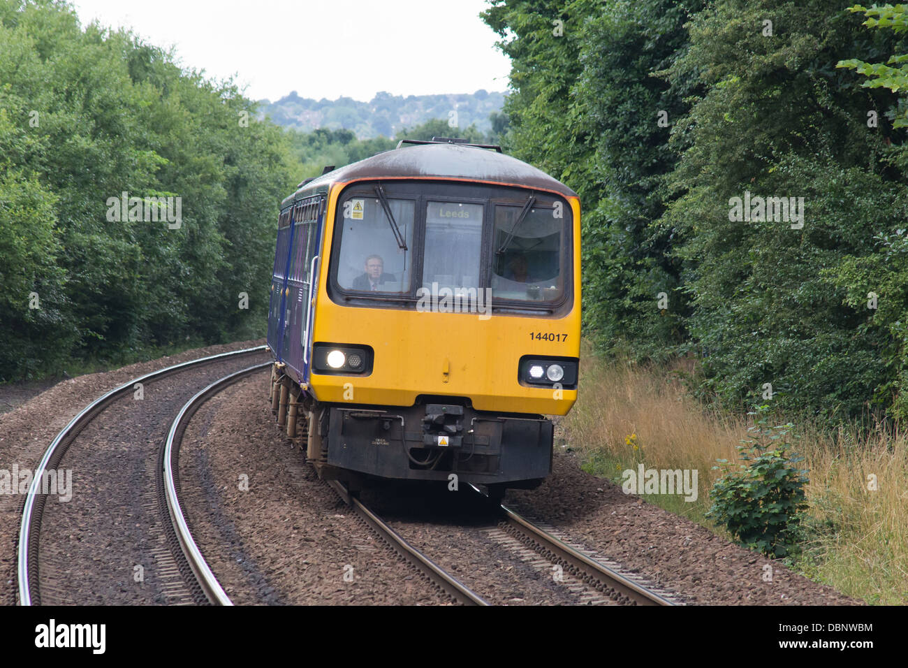 A diesel passenger train on the mainline approaching Deighton station near Huddersfield, West Yorkshire, England Stock Photo