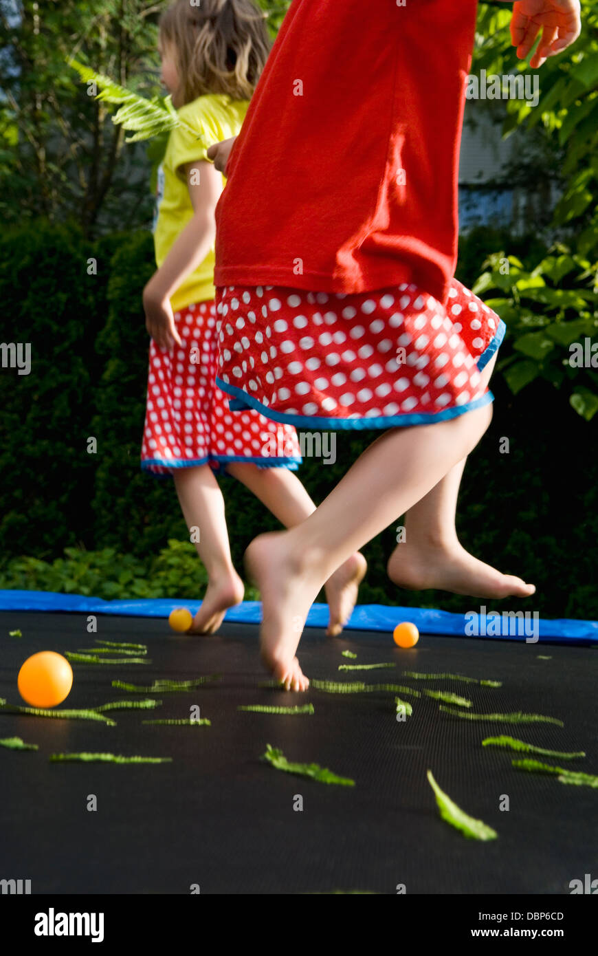 Two girls (4-5) jumping on trampoline Stock Photo