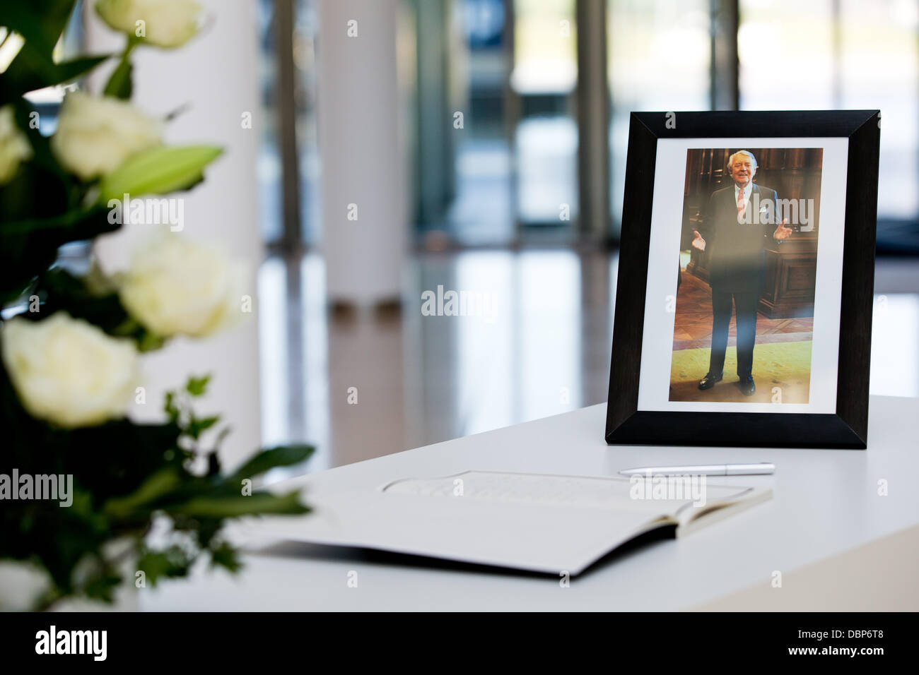 A photo of the deceased chairman of the Alfried Krupp von Bohlen und Halbach Foundation, Berthold Beitz, stands next to a book of condolence at the group's headquarters in Essen, Germany, 02 August 2013. Photo: ROLF VENNENBERND Stock Photo
