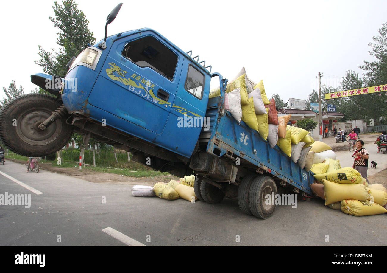 TIPPY TOE TRUCK REACHES TIPPING POINT     A lorry load o' trouble became a truckin' disaster for a driver, who took his farmer's delivery service to unprecedented heights and, promptly, got the sack.....tons of 'em! The overloaded vehicle, travelling on t Stock Photo