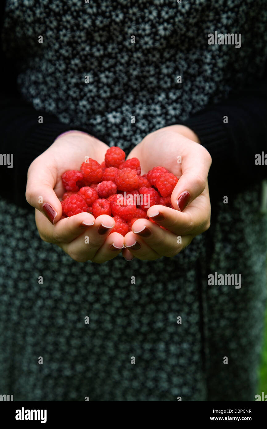 Girl (14-15) holding raspberry in hand Stock Photo - Alamy