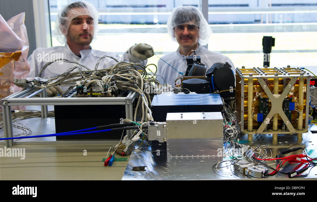 Research assistants Rouven Witt (L) and Nico Bucher check the flatsat of the satellite 'Flying Laptop' in Stuttgart, Germany. Stuttgart University is building its own powerful small satellite to obeserve the earth starting in August 2014. Photo: DANIEL BOCKWOLDT Stock Photo