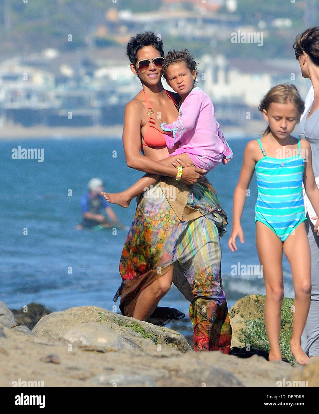 Halle Berry looks in great spirits as she spends her 45th birthday on Malibu Beach with her close family and friends. The actress looked stunning in her bikini as she relaxed with a few drinks and got her feet wet whilst playfully jumping around in the sh Stock Photo