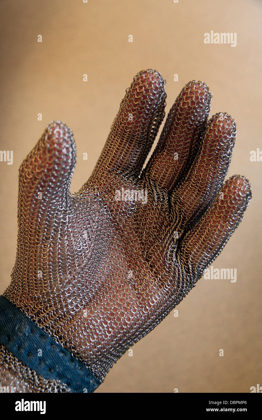 A chain mail glove. Mail (chainmail, maille) is a type of armour consisting of small metal rings linked together in a pattern t Stock Photo