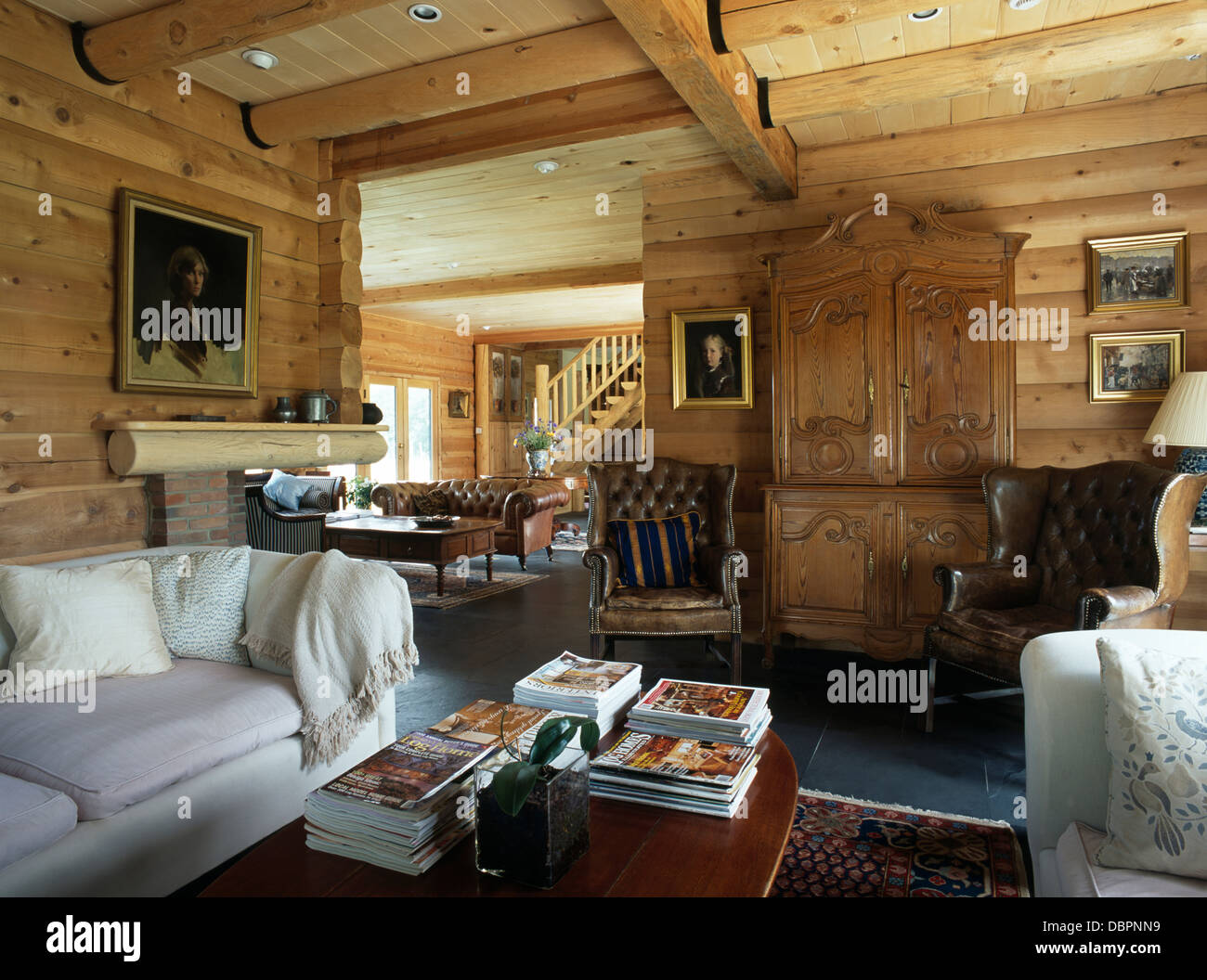 White Sofas In Living Room With Timbered Walls And Cupboard