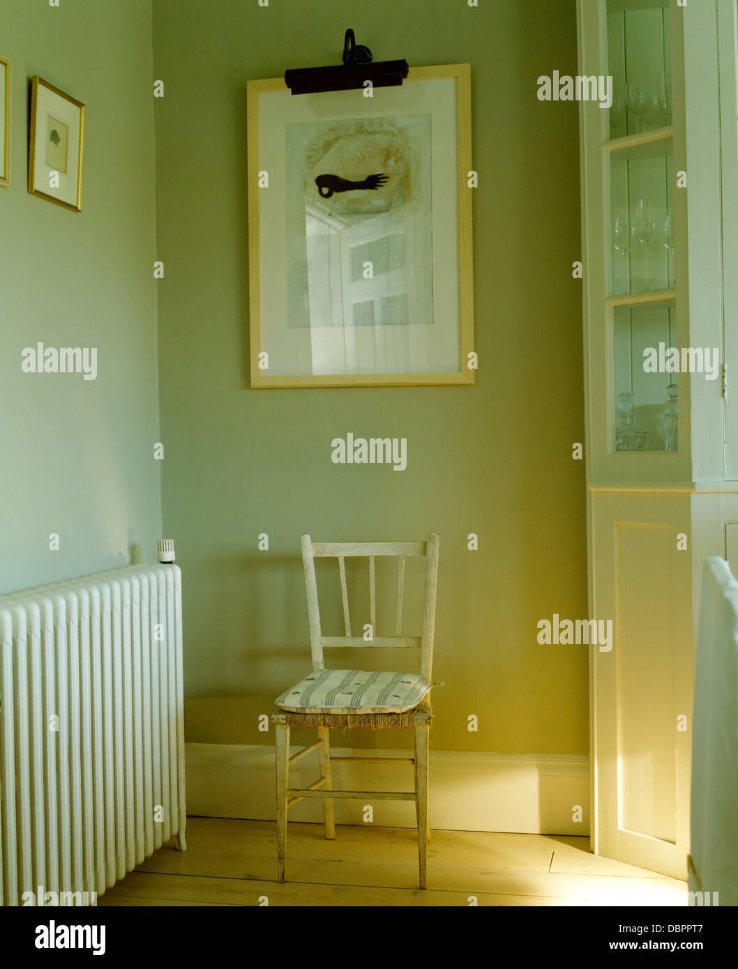 Picture above painted rushseated chair in corner of pale graygreen