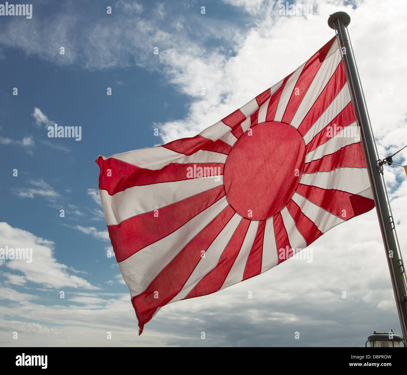 The Japanese Naval Ensign: the Rising Sun Flag, white with a red disc slightly to the hoist with 16 rays extending. Stock Photo