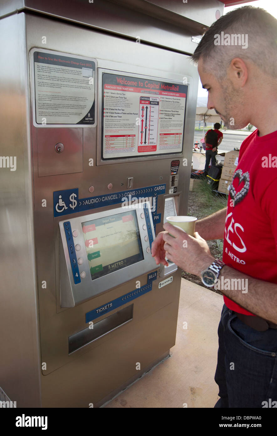 Morning commuter uses the Metro-Rail ticket payment kiosk at public transportation stations in Austin, Texas Stock Photo