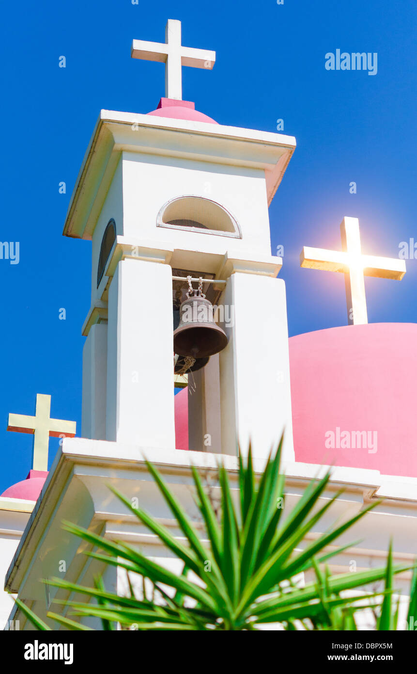Sun shine reflection in golden crosses on pink domes of Greek Orthodox Church of the Seven Apostles in Capernaum Stock Photo
