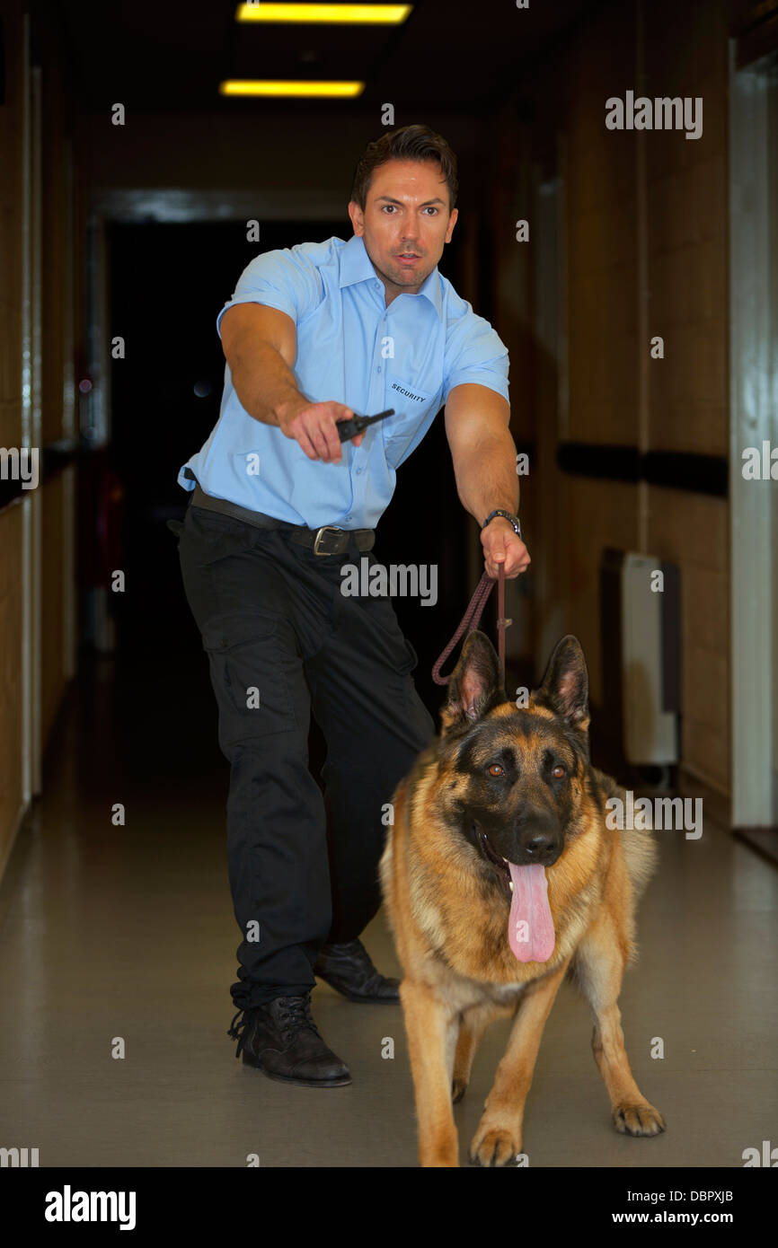 German Shepherd guard dog and handler patrolling the corridors of an