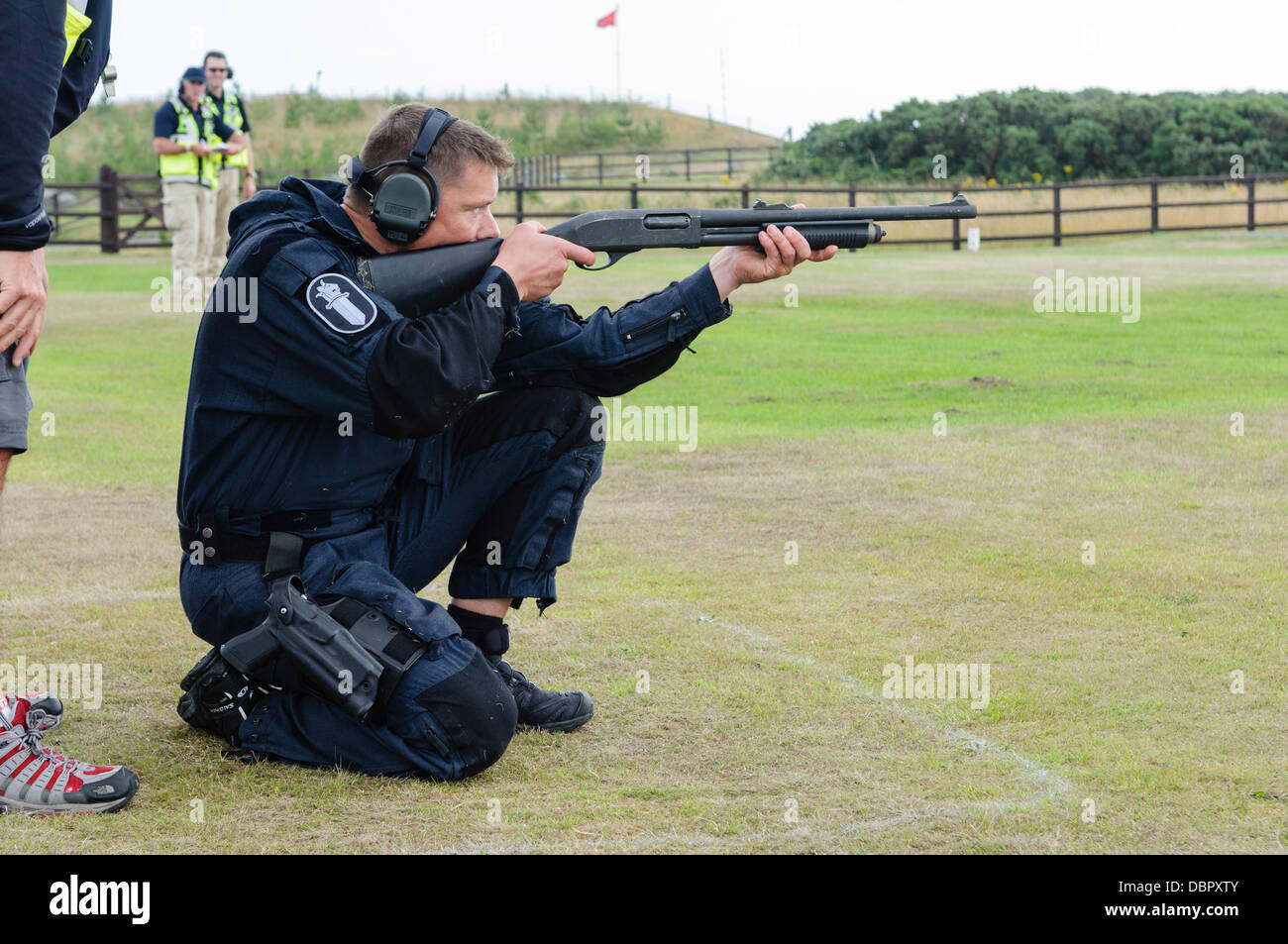 Ballykinlar, Northern Ireland. 2nd August 2013 - A Finnish police officer fires a pump-action shotgun at a firing range Stock Photo