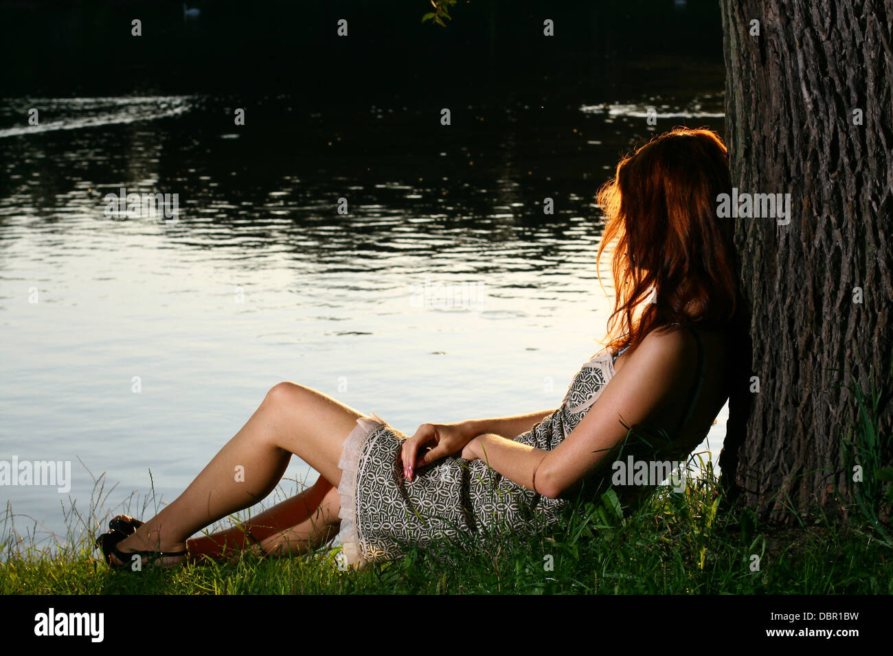 Girl sitting on tha bank of forest river Stock Photo - Alamy