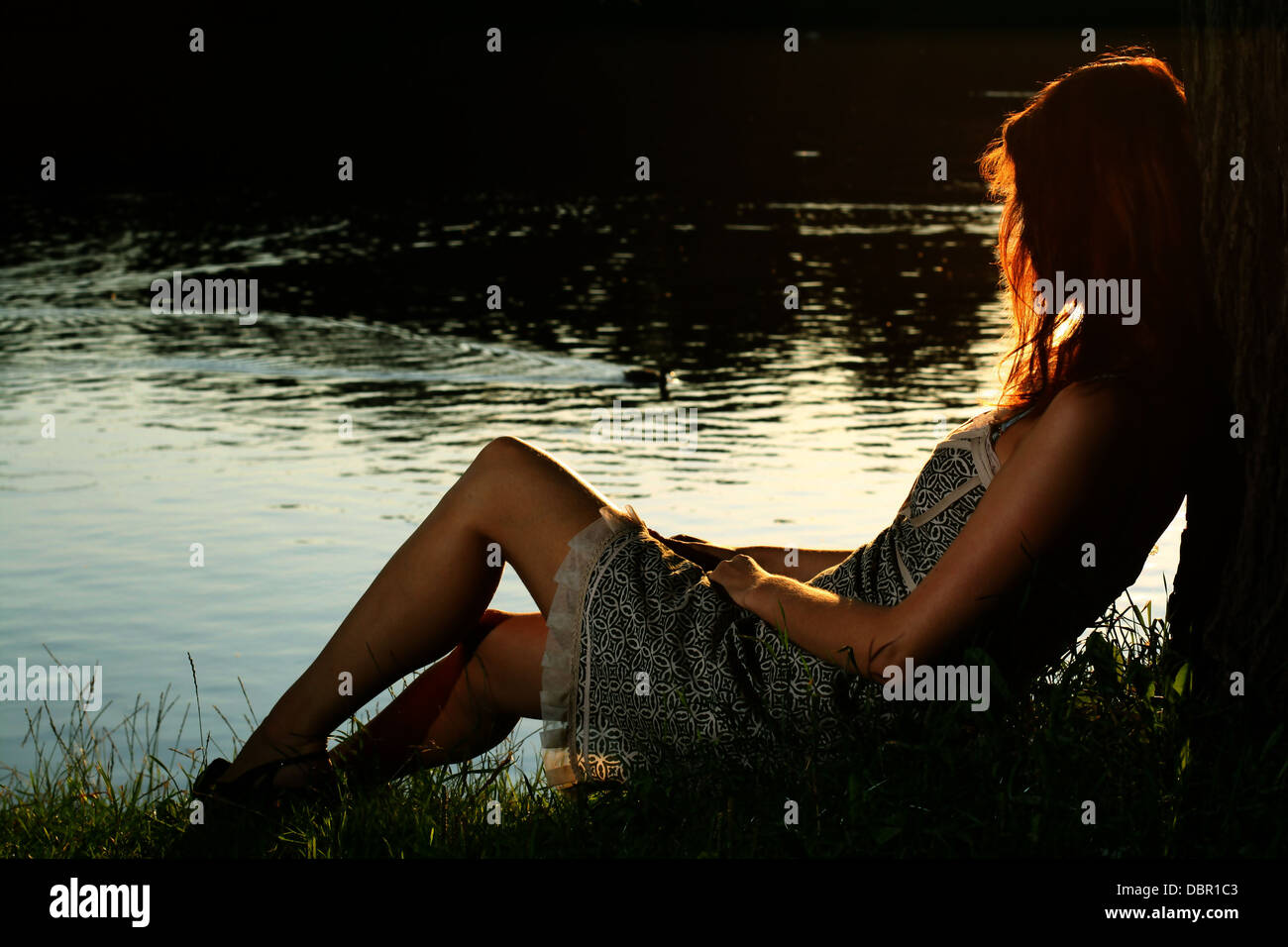 Girl sitting on tha bank of forest river Stock Photo - Alamy