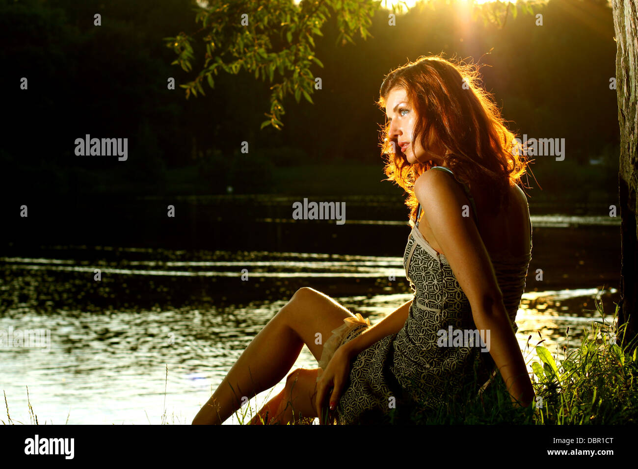 Girl sitting on tha bank of forest river Stock Photo - Alamy