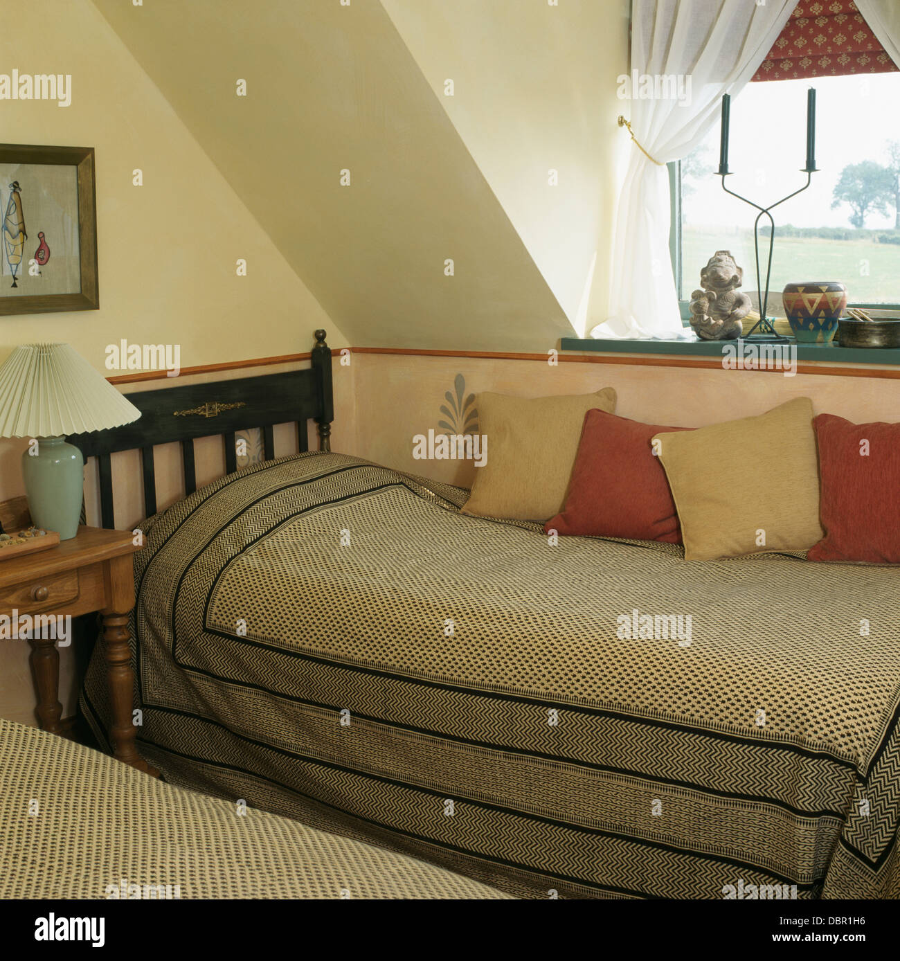 Patterned gray cotton bed covers on twin beds in economy-style attic bedroom Stock Photo
