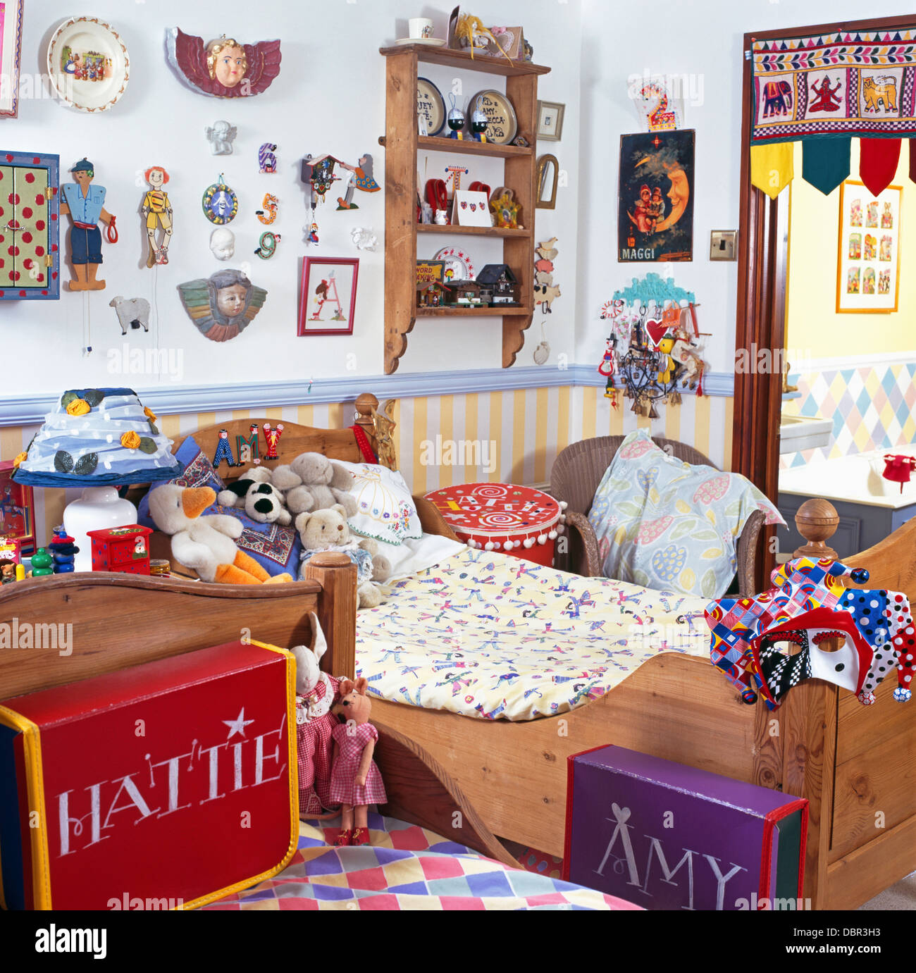Colorful boxes with painted names in children's bedroom with old pine beds and wall shelves Stock Photo
