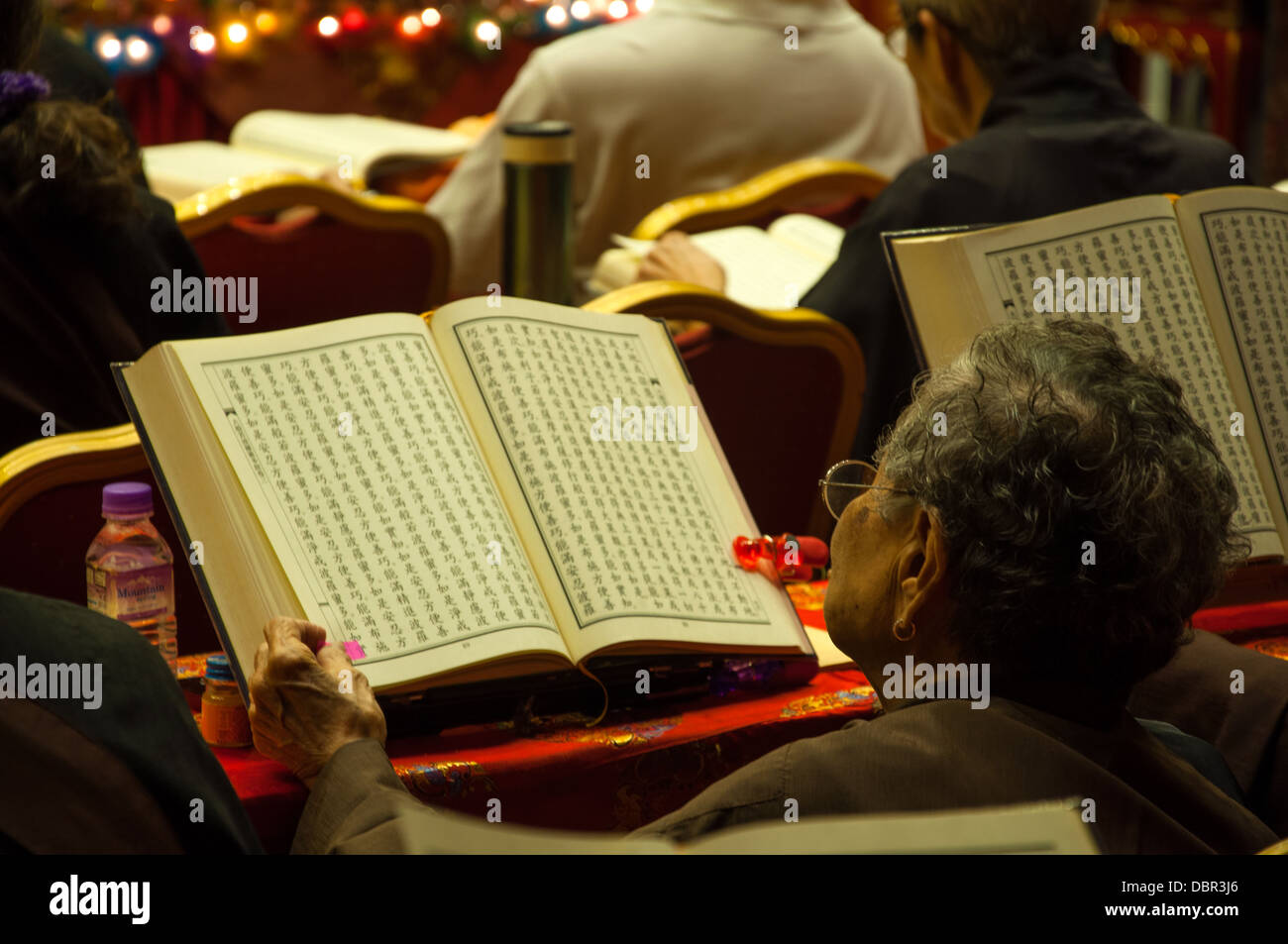 Elder woman praying mantras at Buddha Tooth Relic Temple Stock Photo