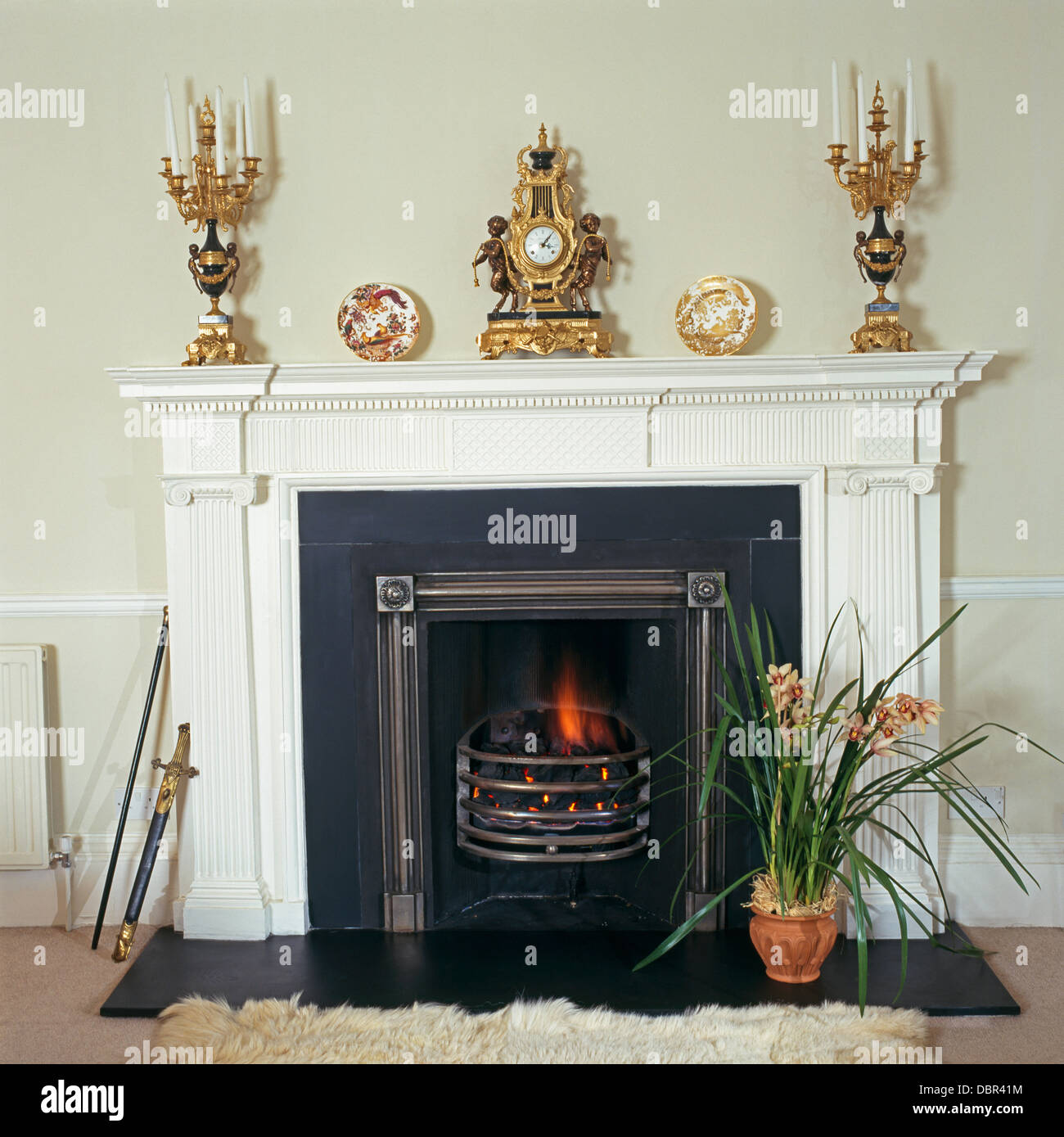 Gilt candelabra and antique gilt clock on mantelpiece above fireplace
