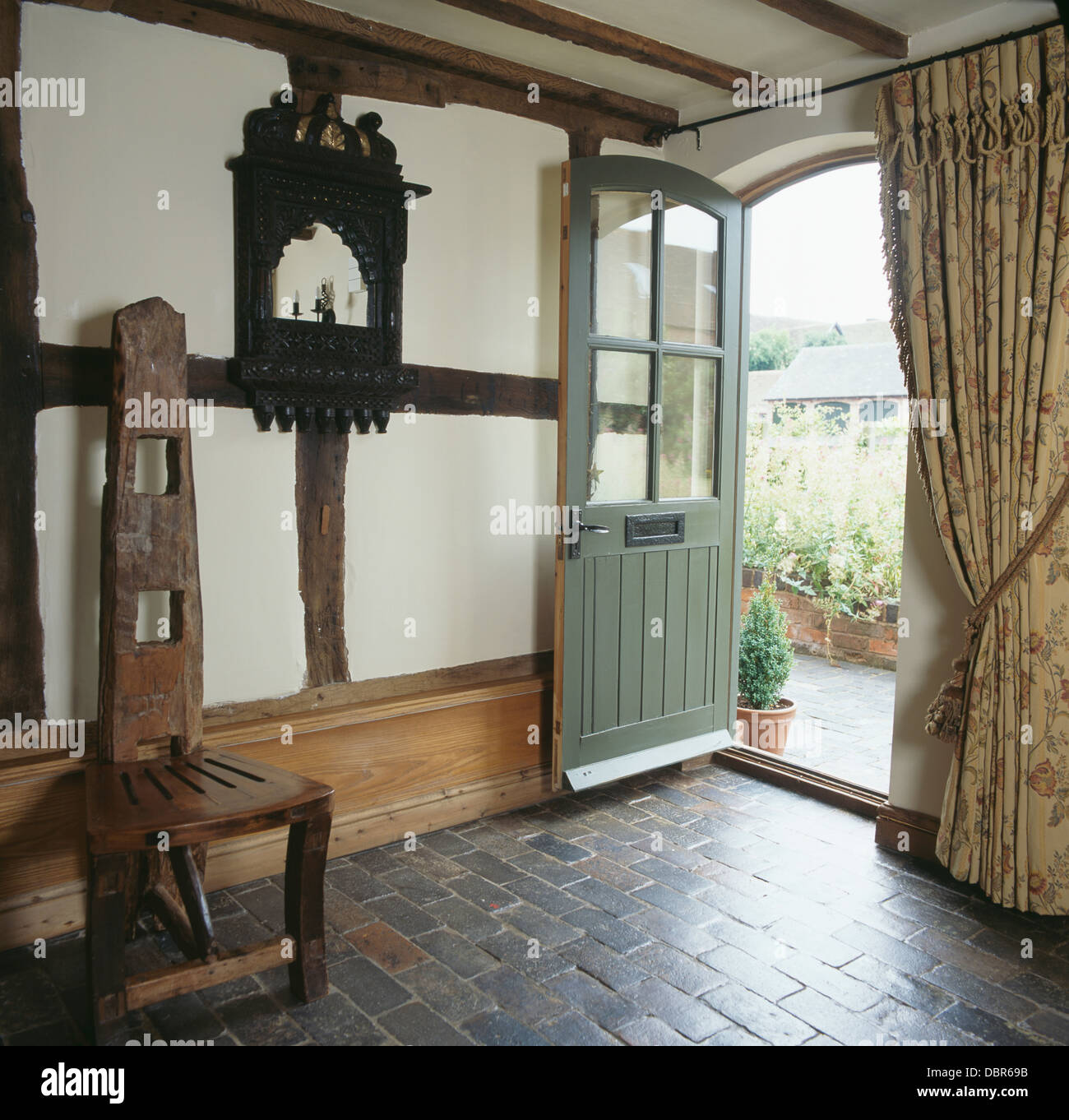Tall-back hand-crafted wooden chair and gray brick flooring in cottage ...