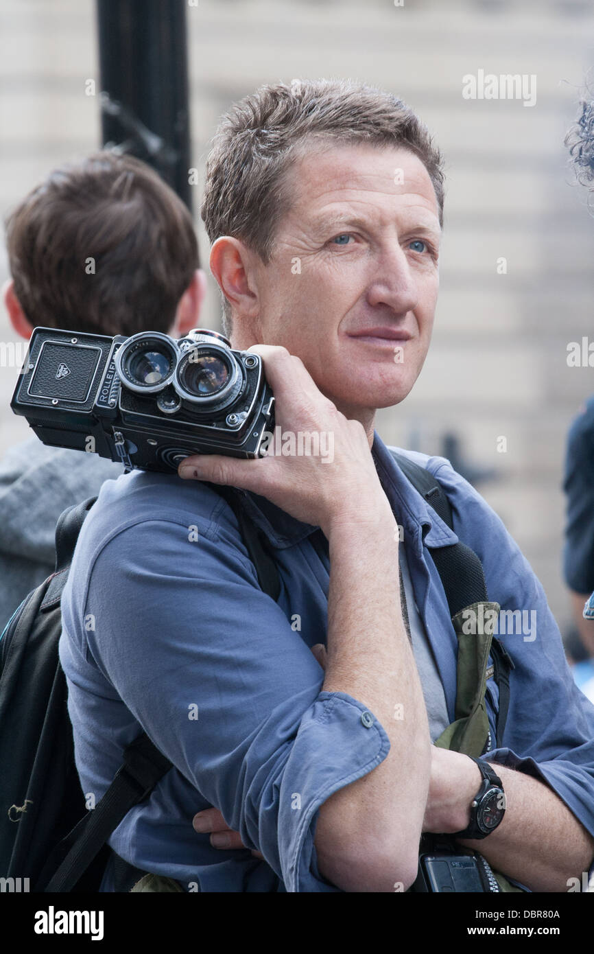 Photographer holding a twin lens rolleiflex camera at G20 Summit Protest outside Bank of England, London, UK Stock Photo