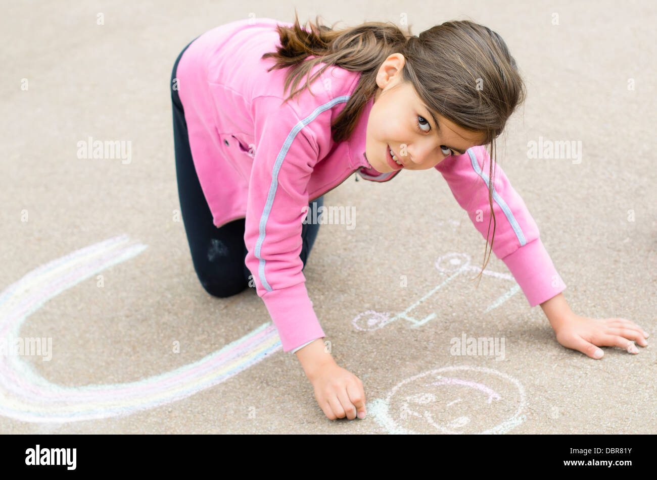 Happy Girl with her drawing on sidewalk Stock Photo