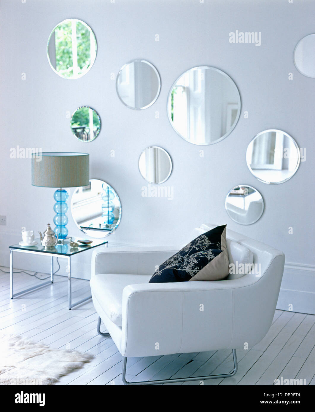 White Leather Chair And Small Glass Table With Glass Lamp In