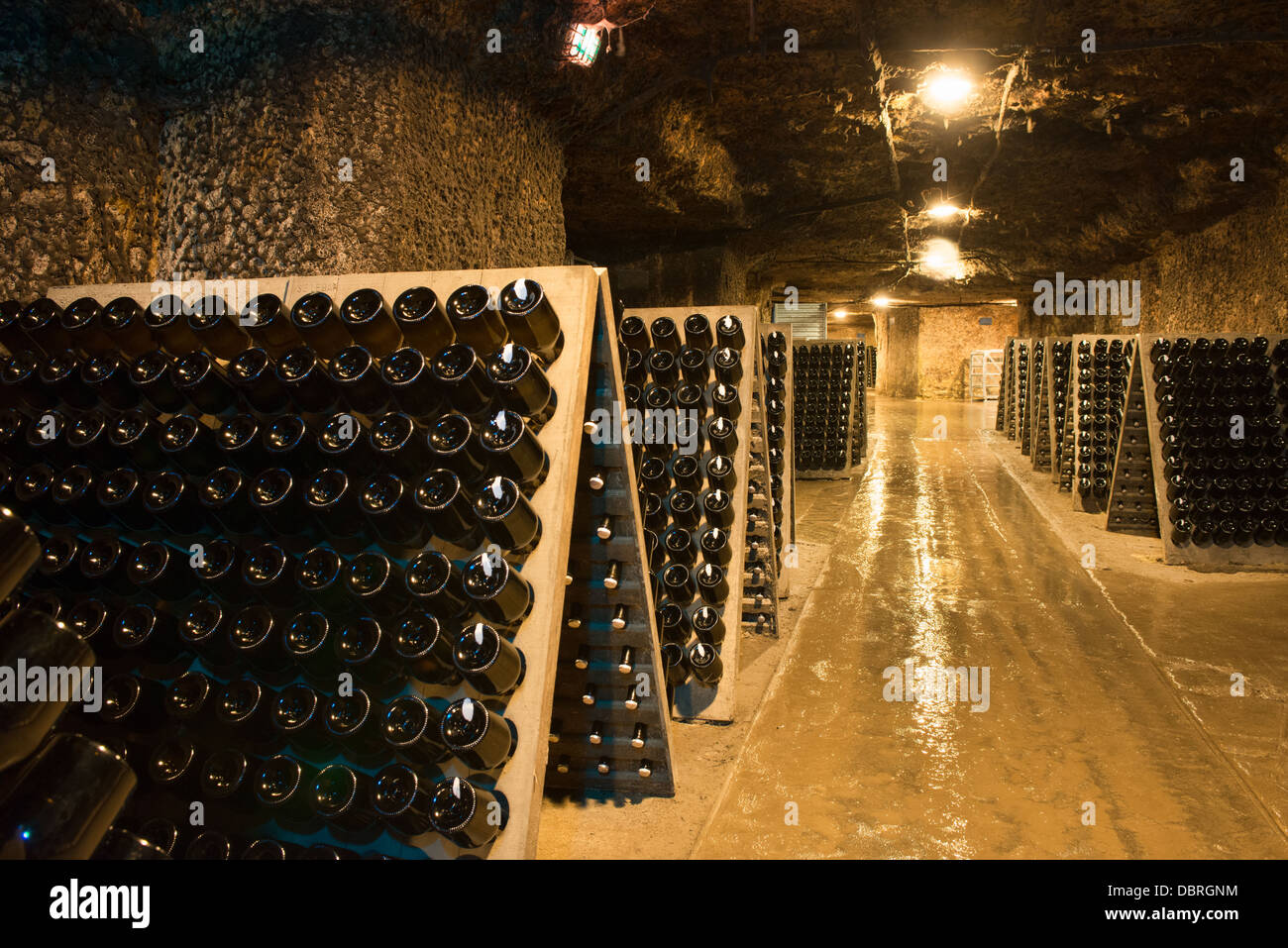 Wine bottles, racked, aging in the "caves touristique" cellars of