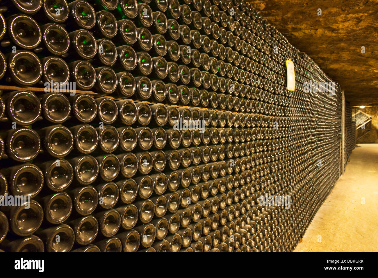 Wine bottles, racked, aging in the "caves touristique" cellars of