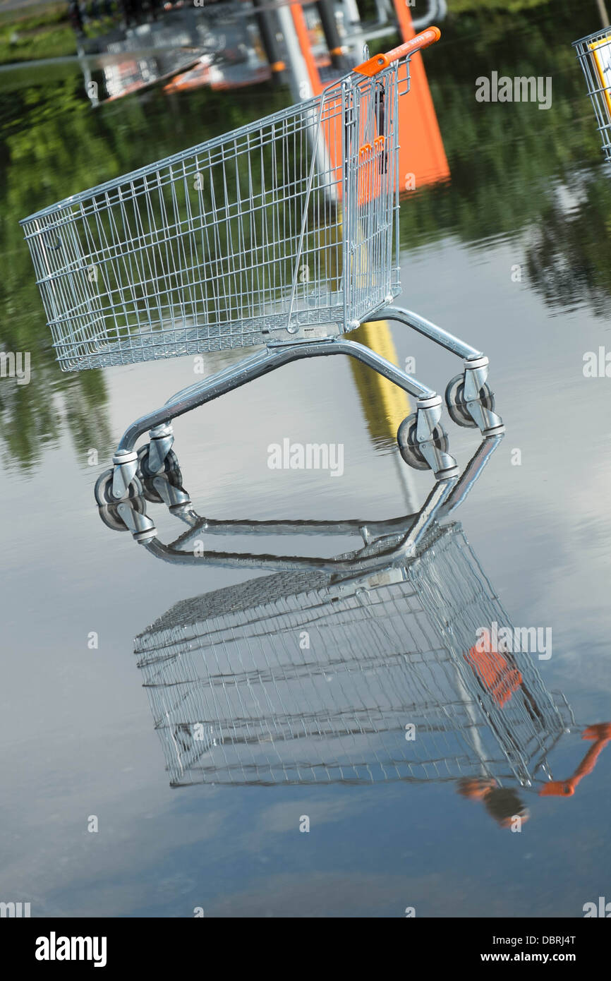A stranded supermaket trolley discarded in a flooded B&Q car park after a heavy rainstorm Stock Photo